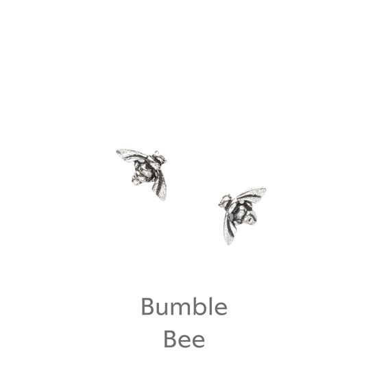 a pair of silver bee earrings on a black background