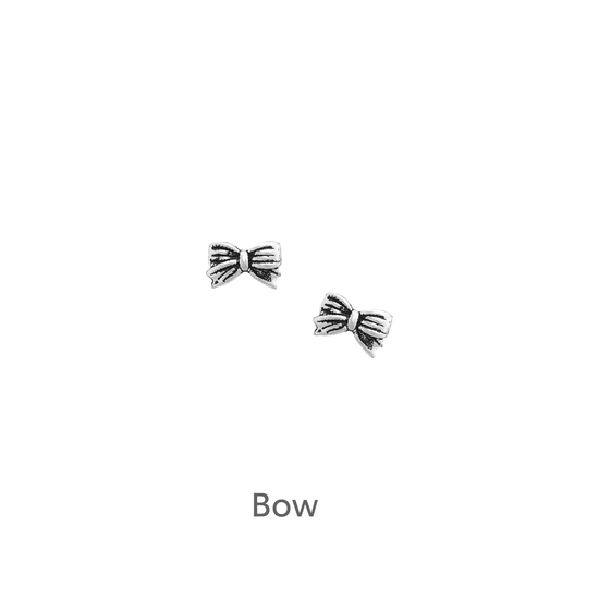 a pair of silver bow earrings on a black background