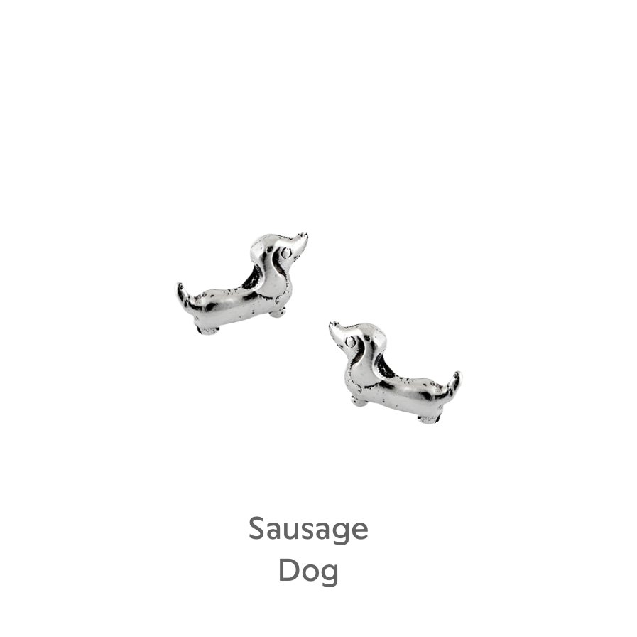 a pair of silver dog cufflinks on a black background