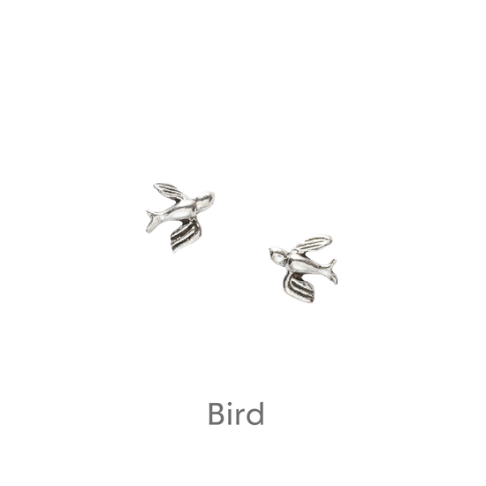 a pair of silver earrings on a black background